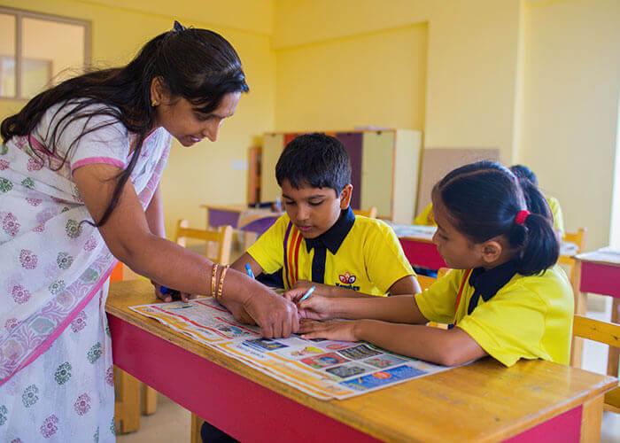 Teacher guiding students in a personalized learning session under the child-centric and focus group program at Galaxy Public School.