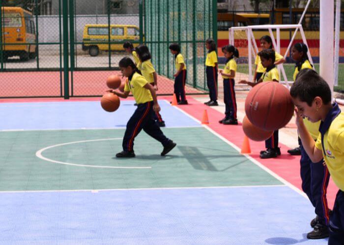 Students enjoying basketball and other sports at the multi-sports facility at Galaxy Public School, Yelahanka.